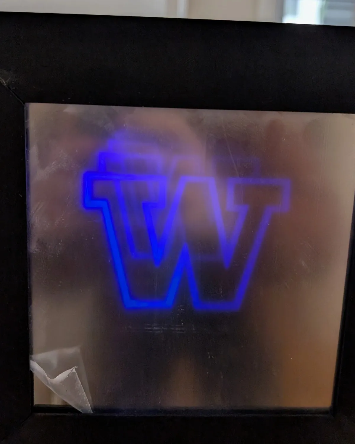 The mirror displaying a custom University of Washington W in glowing blue